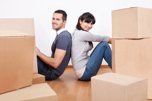 Movers carrying furniture through a South Hackney flat entrance